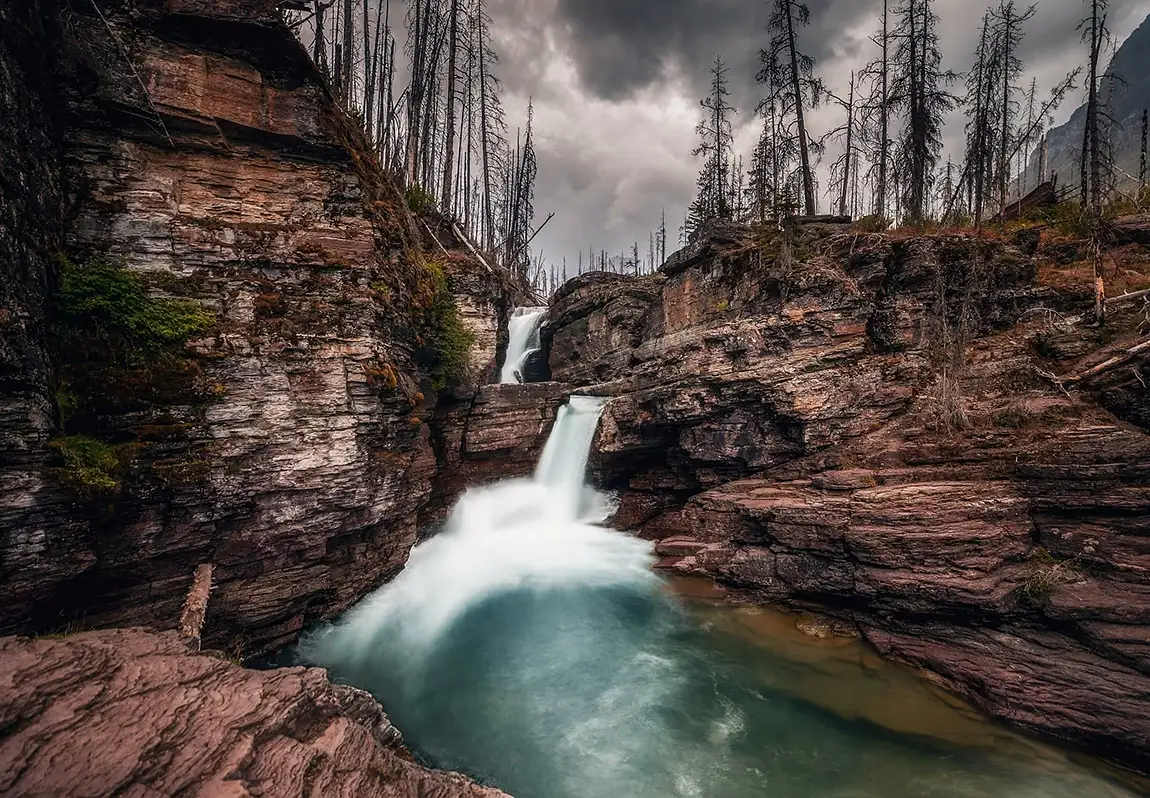 Stormy st mary falls in rocky canyon, glacier national park, montana, usa